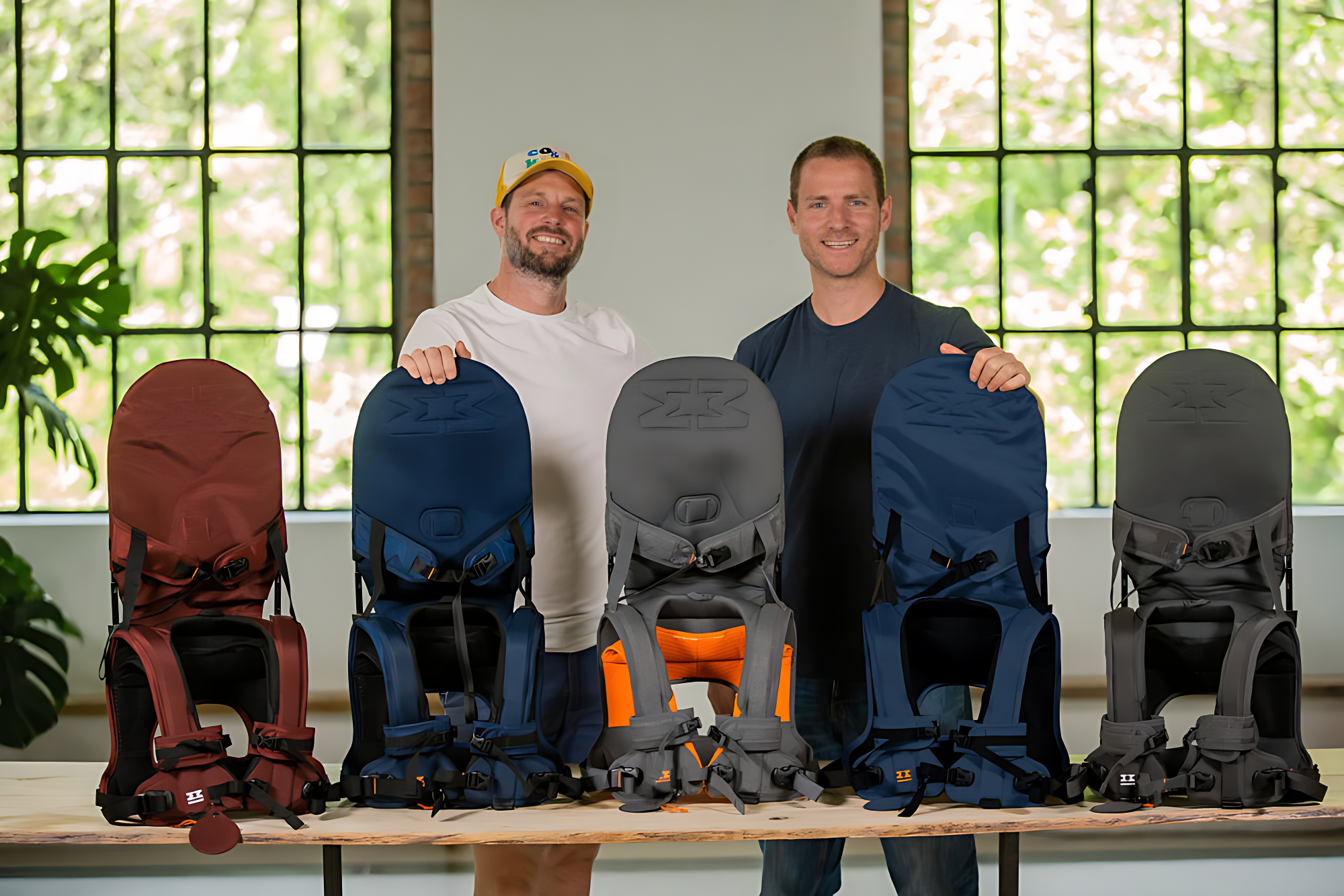 The twin MiniMeis founders standing behind a row of MiniMeis g4
